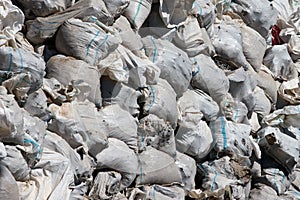 Pile of garbage and trash in white torn plastic bags