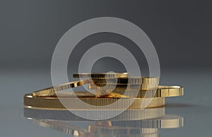 A pile of gold coins of different sizes on a grey background.