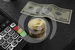 A pile of gold Dash coins and POS terminal. Bitcoins Cryptocurrency. E-commerce, business, finance concept, banking and