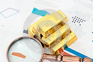 A pile of gold and a magnifying glass on the document