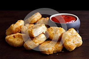 Pile of golden deep-fried battered chicken nuggets with empty ru photo