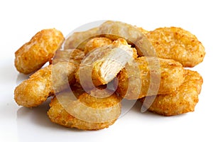 Pile of golden deep-fried battered chicken nuggets isolated on w