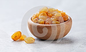 Pile of golden raisins on gray background