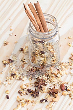 The Pile of granola cereal and cinnamon sticks on the wood backgroun