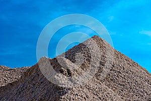 A pile of gravel looking picturesque against the blue sky background.