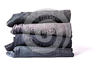 Pile of gray jeans isolated on white