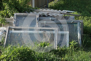 A pile of gray old wooden frames of glass and windows