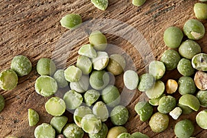 Pile of green peas on the top of wooden barrel, close-up, top view, selective focus.