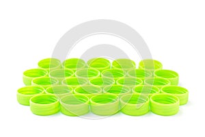 Pile of green plastic bottle cap on white background
