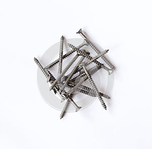 Pile of grey metal wood screws on plain white background