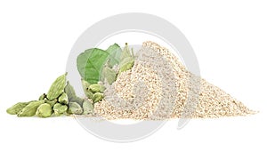 Pile of ground cardamom, green leaves and whole capsules of cardamom, isolated on white background