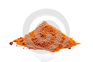 A pile of ground powder paprika isolated on white background, close-up, shallow depth of field