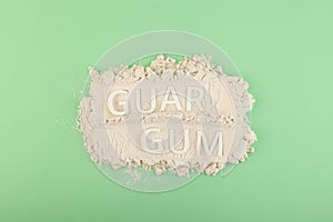 Pile of Guar gum powder or guaran. Inscription GUAR GUM. Food additive E412. Fat Replacer, Dough Improver, Improve Moisture,