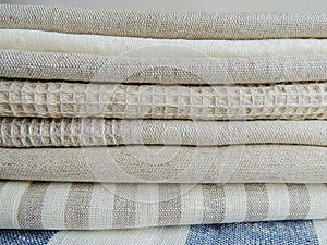 Pile of handmade waffle linen cotton napkins, towels on white linen background.