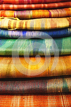 Pile of handwoven silk textiles in rainbow colors