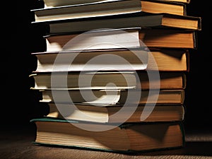 Pile of hardcover books in a shadowy room