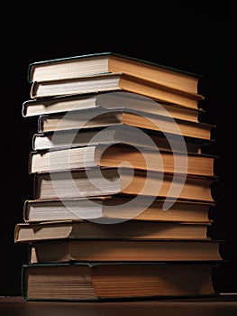 Pile of hardcover books in a shadowy room