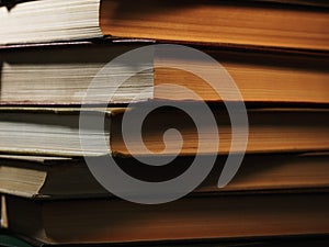 Pile of hardcover books in a shadowy room