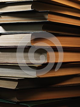 Pile of hardcover books in a shadowy room