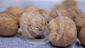 A Pile of Harvested Whole, Ripe Brown Walnuts Lies on the Table. Close-up. Zoom