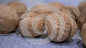 A Pile of Harvested Whole, Ripe Brown Walnuts Lies on the Table. Close-up. Zoom