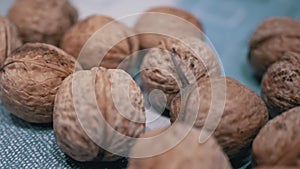 A Pile of Harvested Whole, Ripe Brown Walnuts Lies on the Table. Close-up. Zoom