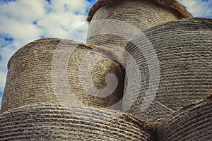 Pile of hay bales on the field at sunny day. Detail view of big rolled haystack. Close up of round hay rolls on meadow