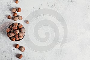 Pile of hazelnuts filbert in a bowl on a white background. Fresh nuts in their shells.
