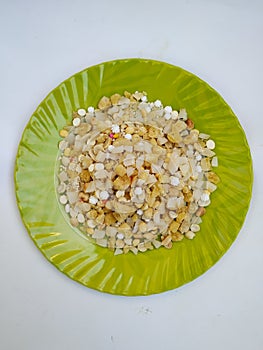 Pile of a Pongal Traditional Raw Mixtures of Ellu Bella in a Green Plate  on white Background photo