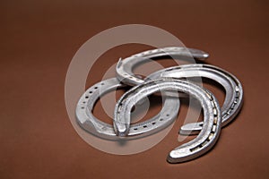 Pile of horseshoes on a brown background