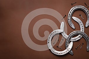 Pile of horseshoes and nails on a brown background