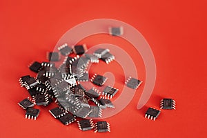 Pile of Integrated circuit chip red on background with copyspace. Microchip type soic8. Electronic components and spare part