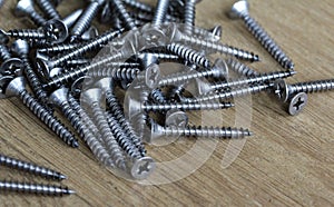 Pile of iron crosshead nails on wooden background