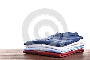 Pile of ironed clothes on table against white