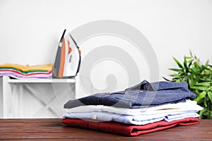 Pile of ironed clothes on table in room