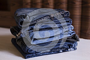 Pile of jeans on a wooden background