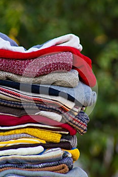 A pile of jerseys stacked and folded against green background outdoor fashion