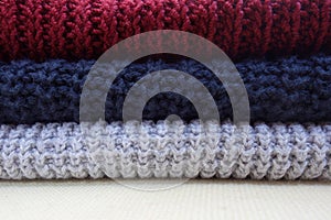 Pile of knitted cotton pullovers of different colors photo