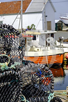 Pile of Lobster Or Crab Fishing Pots With Fishing Boat In The Background
