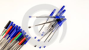 Pile of a lot multi colored plastic ballpoint pens on white background. Abstract stationery background. 16x9 format. Top view.