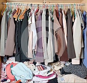 Pile of messy clothes in closet. Untidy cluttered woman wardrobe