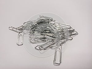 Pile of metal paper clips on a white background