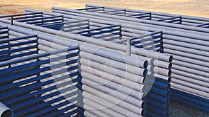 Pile of metal roof beams stacked on the ground in construction site area