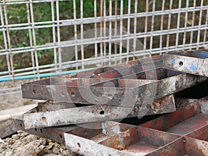 Pile of metallic molds for building a concrete fence at a construction site