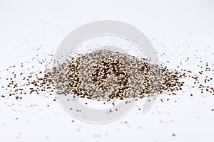 The pile of mixed raw quinoa seeds (white, red, and black) on white background.