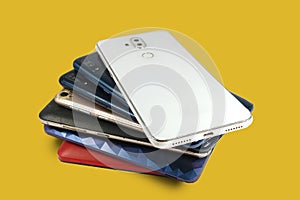 Pile of mobile phones, Back view of smartphone isolated on yellow background