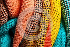 A pile of multi-colored knitted fabrics