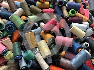 pile of multi-colored spools of thread close-up