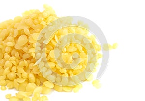 Pile of Natural Yellow Beeswax Pearls on a Wax Background