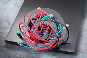 A pile of network wires on a laptop, a concept on the topic of confusion in connecting to a local network or the Internet